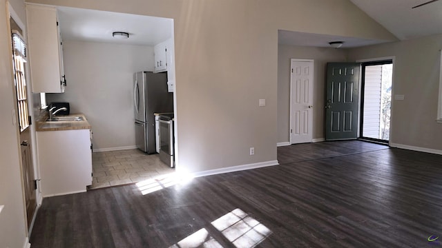 kitchen featuring lofted ceiling, sink, stainless steel appliances, dark hardwood / wood-style floors, and white cabinets