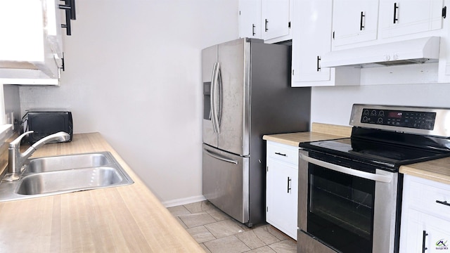 kitchen with premium range hood, sink, white cabinetry, light tile patterned floors, and appliances with stainless steel finishes