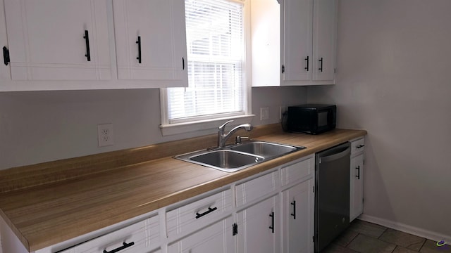 kitchen featuring white cabinetry, sink, tile patterned floors, and dishwasher