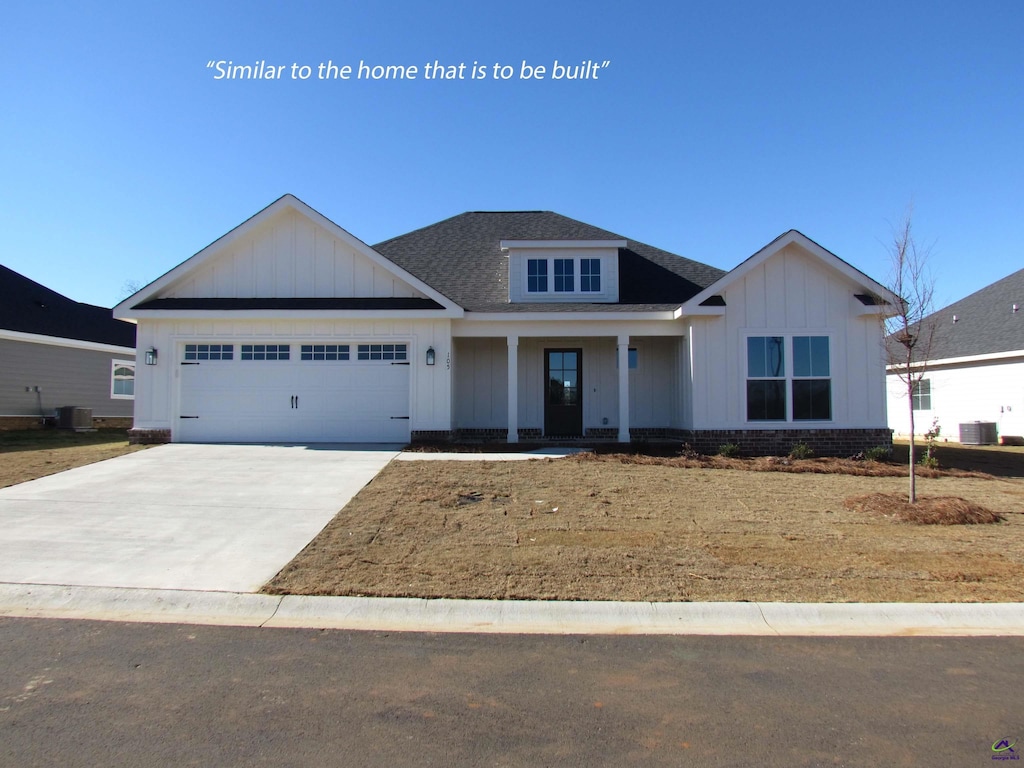 view of front of property with a garage and central AC