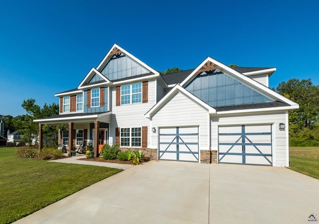 craftsman house featuring a garage, covered porch, and a front lawn