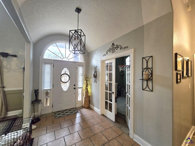 entryway with vaulted ceiling and a textured ceiling