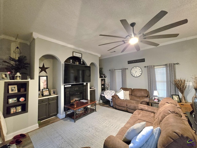 living room featuring crown molding, ceiling fan, hardwood / wood-style flooring, and a textured ceiling