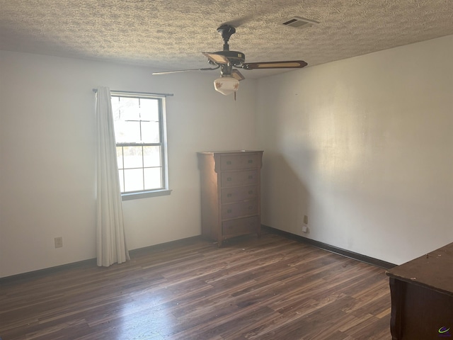 unfurnished room with ceiling fan, dark hardwood / wood-style floors, and a textured ceiling