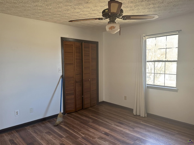 unfurnished bedroom featuring multiple windows, ceiling fan, dark hardwood / wood-style floors, and a closet