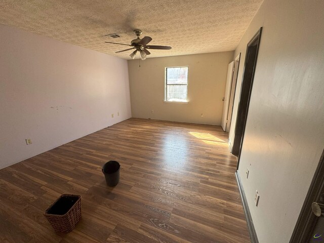 unfurnished room featuring ceiling fan, dark hardwood / wood-style floors, and a textured ceiling