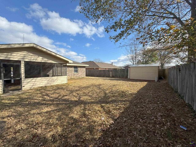 view of yard featuring a storage shed and a sunroom