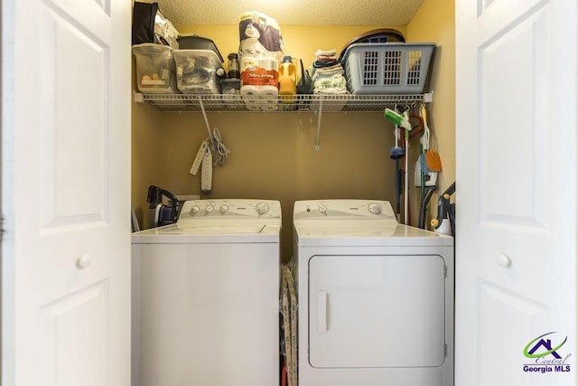 laundry area featuring washer and clothes dryer and a textured ceiling