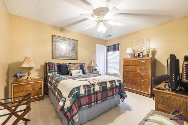 carpeted bedroom with a textured ceiling and ceiling fan