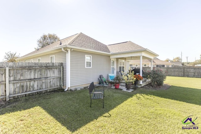 rear view of property featuring a lawn