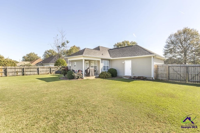 rear view of property with a lawn