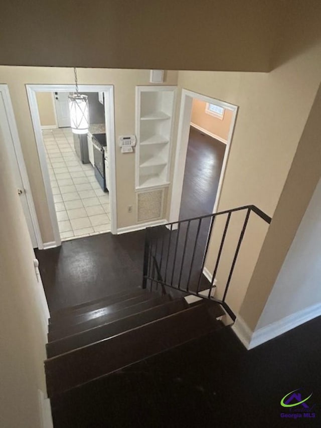 stairs with hardwood / wood-style flooring and built in features