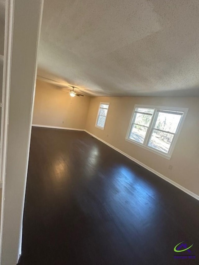 spare room with hardwood / wood-style flooring, ceiling fan, and a textured ceiling