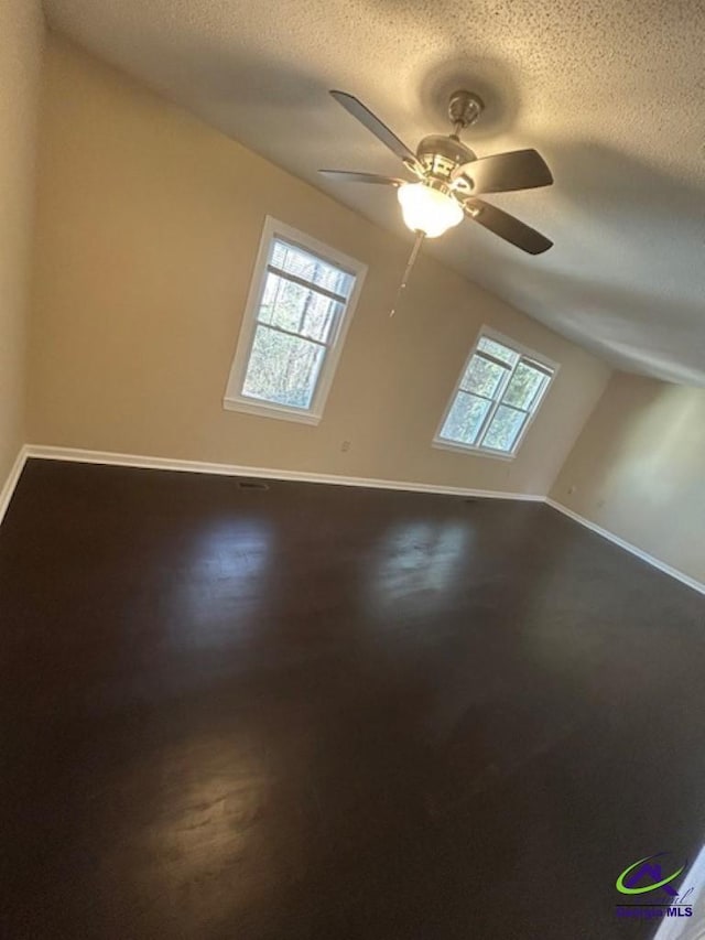 additional living space with ceiling fan and a textured ceiling