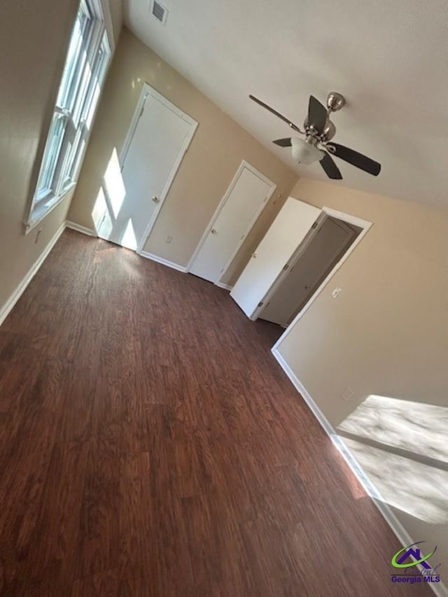 bonus room with a wealth of natural light, dark wood-type flooring, and ceiling fan