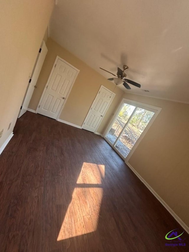 additional living space featuring dark wood-type flooring and ceiling fan