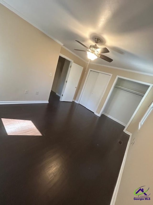 interior space featuring ornamental molding, dark hardwood / wood-style floors, and ceiling fan