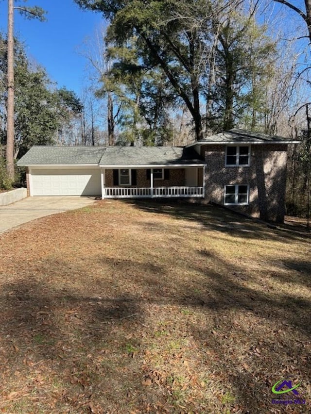 view of front of home featuring a garage, a front yard, and covered porch