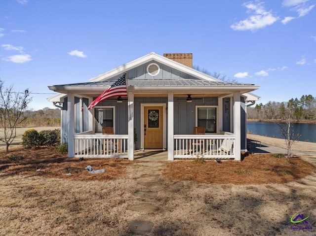 view of front facade with a water view, ceiling fan, and a porch