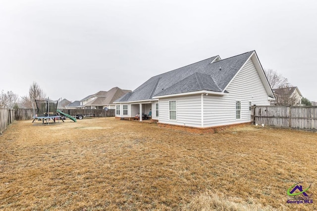 306 Lovorn Cir, Warner Robins, GA 31088 - back of house with a trampoline and roof with shingles