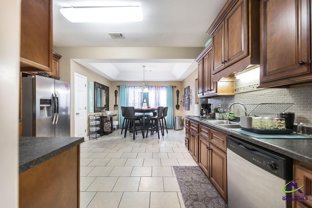 306 Lovorn Cir, Warner Robins, GA 31088 - kitchen with appliances with stainless steel finishes, dark countertops, tasteful backsplash, and a sink