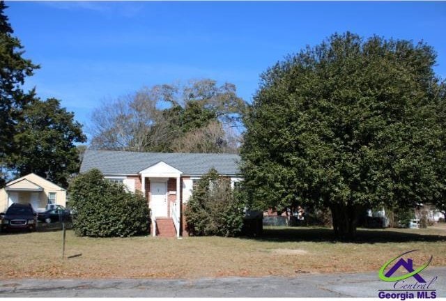 view of property hidden behind natural elements featuring a front lawn