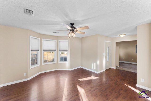 unfurnished room featuring dark wood-type flooring, ceiling fan, and a textured ceiling