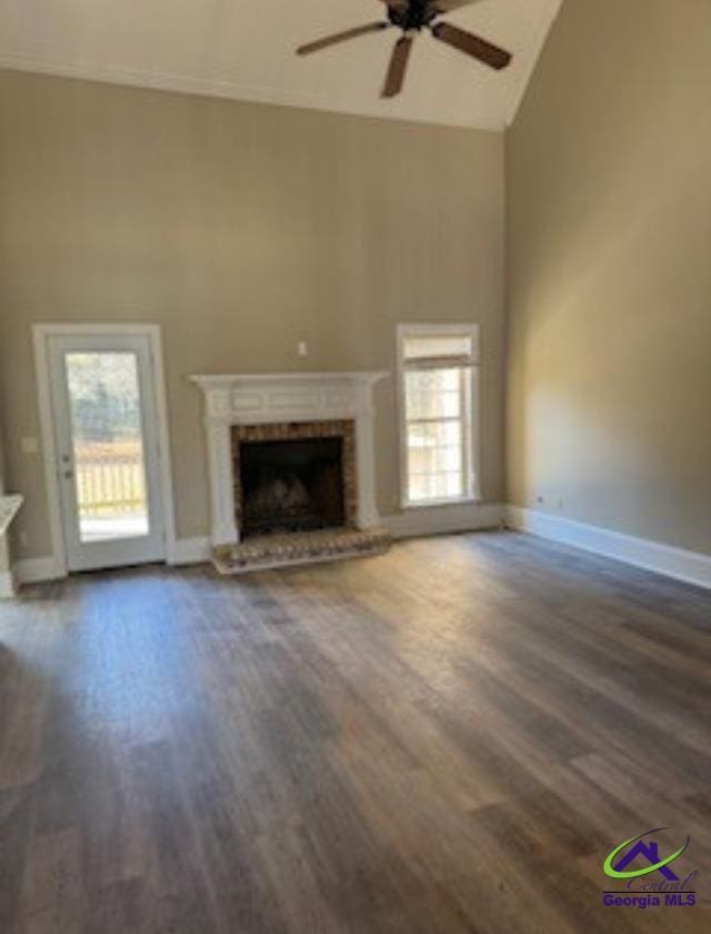 unfurnished living room with dark hardwood / wood-style flooring, a fireplace, high vaulted ceiling, and ceiling fan