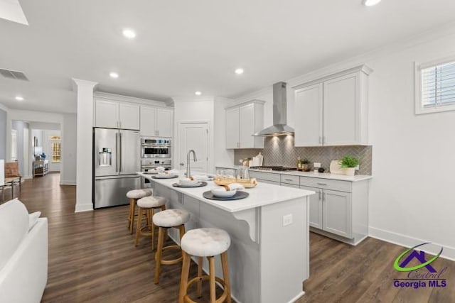 223 Flat Shoals Dr, Bonaire, GA 31005 - kitchen featuring white cabinets, a center island with sink, wall chimney exhaust hood, and appliances with stainless steel finishes