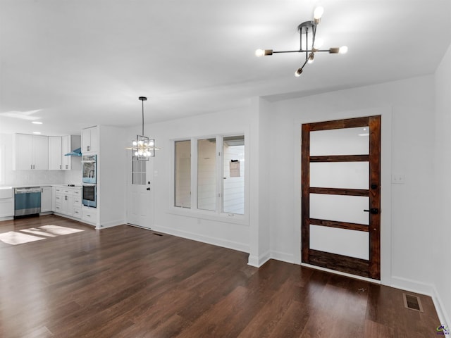 entryway featuring a notable chandelier and dark wood-type flooring