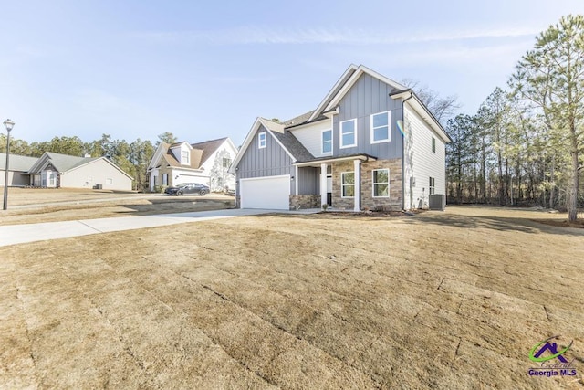 view of front of property with a garage, a front yard, and central air condition unit