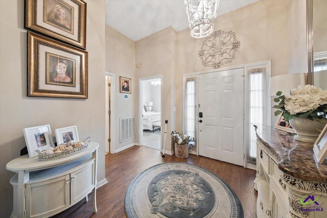 foyer featuring dark wood-type flooring and a high ceiling