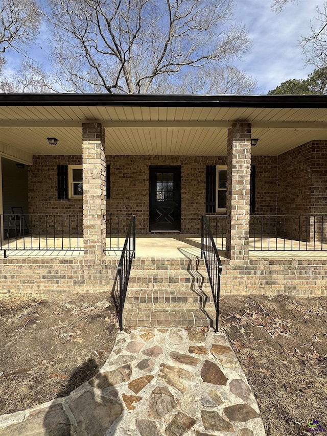 view of exterior entry featuring covered porch