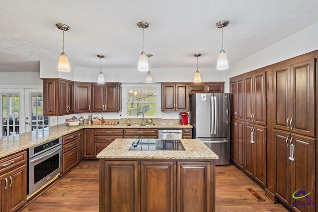 kitchen with stainless steel appliances, sink, a center island, and pendant lighting