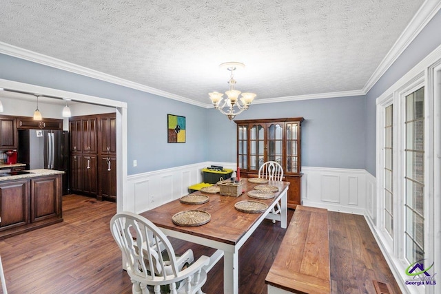 dining space featuring crown molding, dark hardwood / wood-style floors, a chandelier, and a textured ceiling