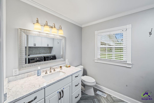 bathroom featuring parquet flooring, toilet, crown molding, vanity, and washer / clothes dryer