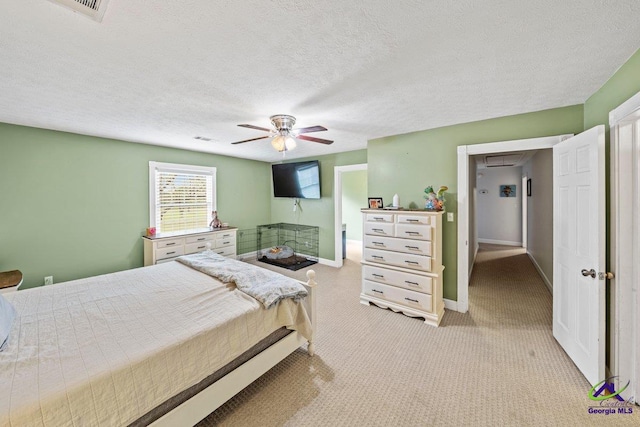 bedroom with light carpet, ceiling fan, and a textured ceiling