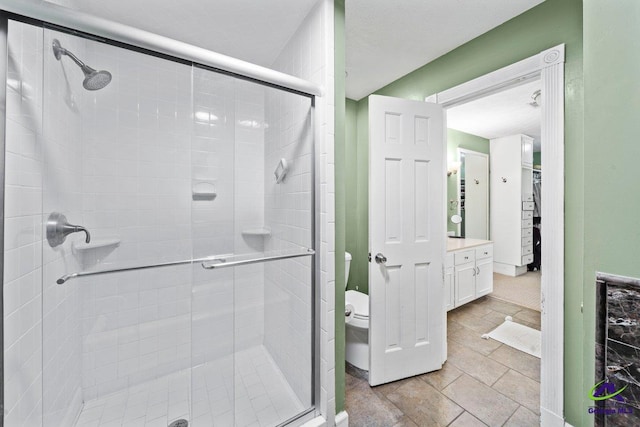 bathroom with a shower with door, vanity, and toilet