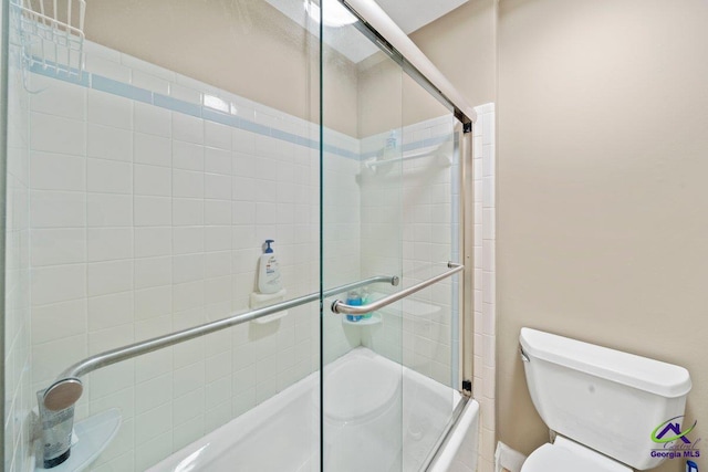 bathroom featuring toilet and combined bath / shower with glass door