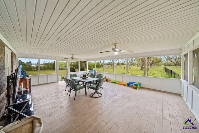 unfurnished sunroom with ceiling fan