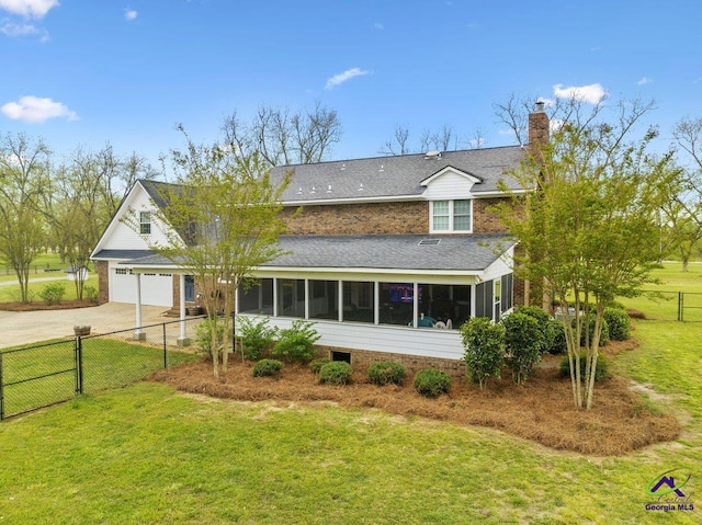 view of front facade with a garage, a sunroom, and a front lawn