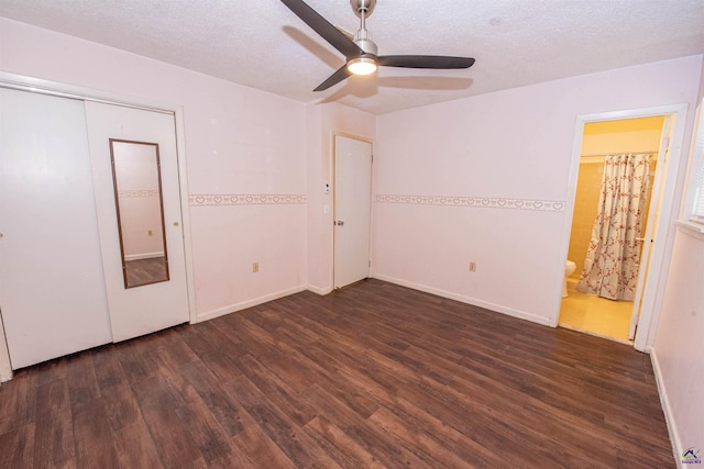 unfurnished bedroom featuring ensuite bathroom, dark hardwood / wood-style floors, ceiling fan, and a textured ceiling