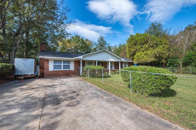 ranch-style house featuring covered porch and a front lawn