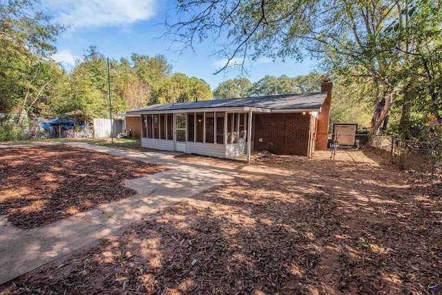 rear view of house featuring a sunroom