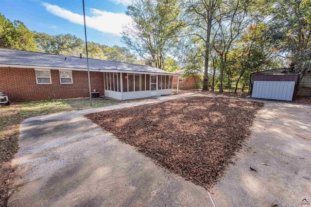 view of yard featuring a sunroom and a shed