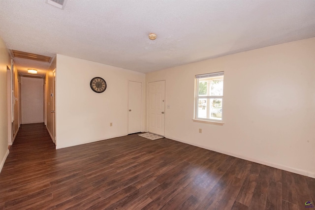 spare room with dark wood-type flooring and a textured ceiling