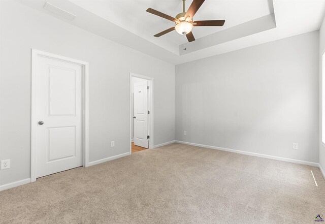 687 Jasmine Dr, Macon, GA 31211 - unfurnished bedroom with carpet flooring, a tray ceiling, baseboards, and a ceiling fan