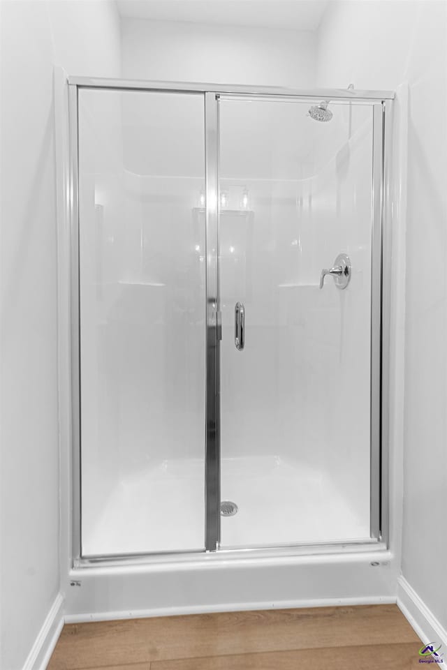 687 Jasmine Dr, Macon, GA 31211 - bathroom featuring baseboards, a stall shower, and wood finished floors