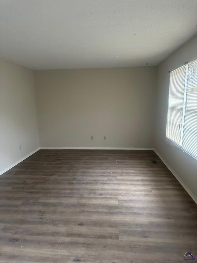 spare room with dark hardwood / wood-style flooring