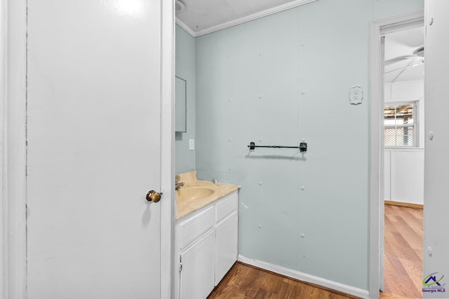 bathroom featuring vanity, hardwood / wood-style flooring, and ornamental molding